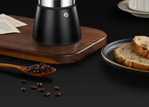 Close-up of matte black espresso Moka pot base on wooden board with coffee beans