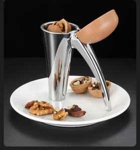 Detailed macro view of a stainless steel funnel nutcracker with walnuts on white plate