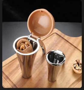 Close-up of stainless steel funnel nutcracker set on wooden board with walnuts