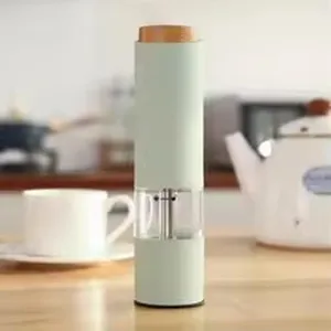 Nahaufnahme einer mintgrünen elektrischen Pfeffermühle auf einem Holz-Küchentisch