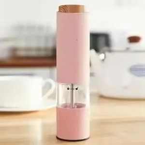 Rosa umweltfreundliche Pfeffermühle aus Weizenstroh auf einem Holztisch in der Küche