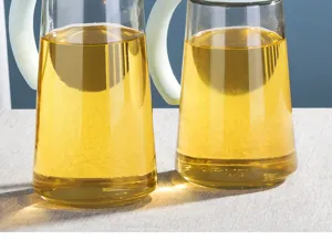 Macro view of transparent glass oil bottles with yellow liquid and light handles