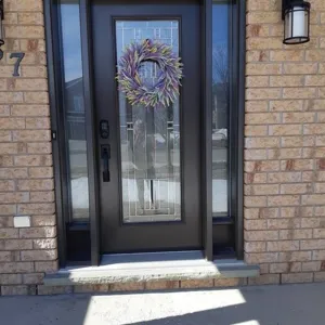 Couronne de lavande artificielle sur une porte d'entrée moderne en verre décoratif