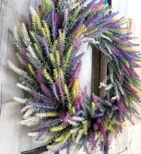 Détail d'une couronne de lavande artificielle multicolore sur fond de bois