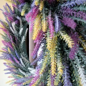 Gros plan d'une couronne de lavande artificielle avec détails floraux violets et jaunes.