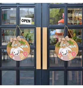 Decorative wooden Easter door sign with bunny and bow shown hanging on a glass door