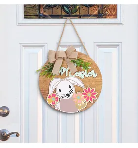 Easter bunny wooden door sign hanging on a white front door with bow decoration