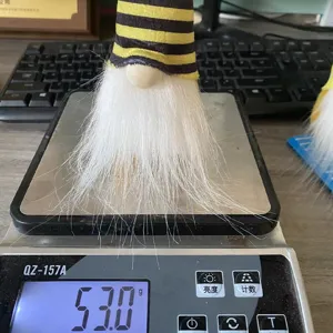 Poupée en peluche de gnome abeille mesurant 53 grammes sur une balance numérique