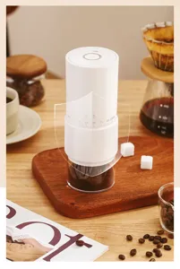 Close-up of portable electric coffee grinder showing the adjustable coarseness scale on wood