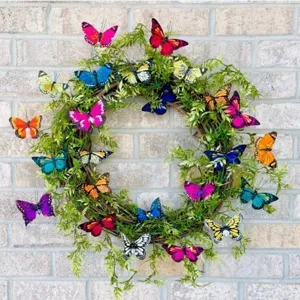 Primer plano de una corona de mariposas artificiales vibrantes en una pared de ladrillo gris