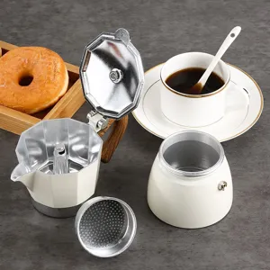 Cream-colored octagonal Moka pot coffee maker disassembled on a dark tabletop