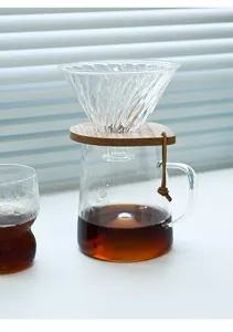 Gros plan du serveur à café en verre résistant à la chaleur avec socle en bois