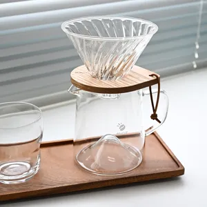 Élégant service à café manuel en verre avec support en bois et carafe sur un plateau