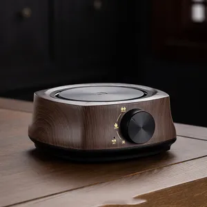 Close-up of a 500W small electric tea stove with wood grain finish on wooden table.