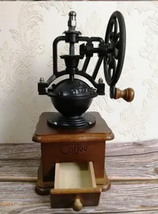 Vintage χειροκίνητος μύλος καφέ με τροχό από χυτοσίδηρο και ξύλινη βάση