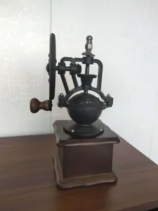 Λεπτομερής όψη vintage χειροκίνητου μύλου καφέ από χυτοσίδηρο με τροχό.