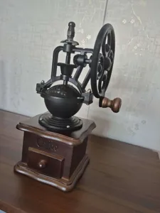 Vintage χειροκίνητος μύλος καφέ από χυτοσίδηρο με ξύλινη βάση και τροχό