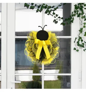 Hermosa corona decorativa de malla de abeja con lazo amarillo y antenas para puerta principal.