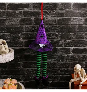 Detail der Halloween Hexenhut-Deko mit gestreiften Beinen an einer Backsteinmauer