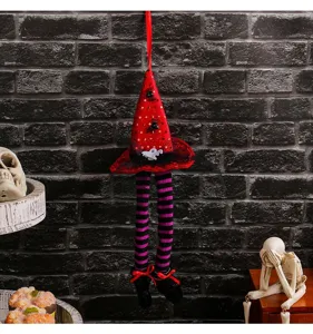 Detailansicht der Halloween-Hexenhut-Deko mit gestreiften langen Beinen an einer Ziegelwand