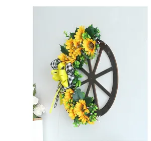 Rustikaler Holzwagenrad-Kranz mit Sonnenblumen und Karoschleife für die Wanddekoration.