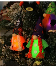 Close-up of glowing Halloween gnomes hanging on a decorated tree branch