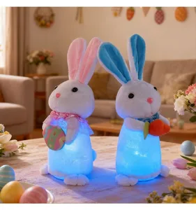 Vista detallada de dos conejitos de Pascua de peluche luminosos en una mesa con huevos