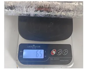 Detailed view showing the 65g weight measurement of a bronzing mesh roll on a scale