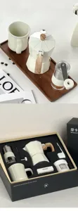 Detailed view of 6-piece manual coffee gift set including white moka pot and coffee grinder
