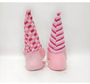 Back view of two adorable pink Valentine's Day gnomes featuring knitted patterned hats