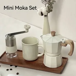 Minimalist creamy white manual coffee grinder and Moka pot gift set on wooden tray