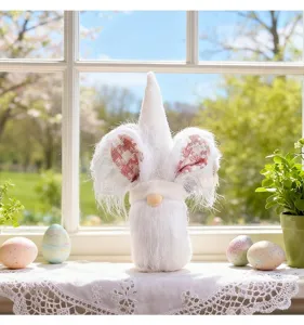 Close-up of white Easter bunny gnome doll decorated on a sunny windowsill with eggs