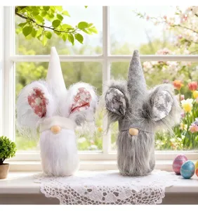 Two decorative Easter gnomes with rabbit ears placed on a windowsill with lace cloth.