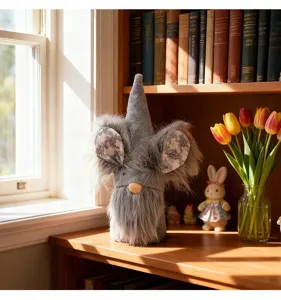 Cute Easter faceless gnome plush with rabbit ears on a sunlit wooden table