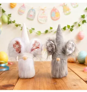 Pair of plush Easter gnomes with rabbit ears and fuzzy white beards on a wooden surface