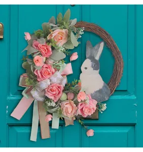 Detailed close-up of an Easter wreath featuring pink roses, eucalyptus leaves, and a rabbit
