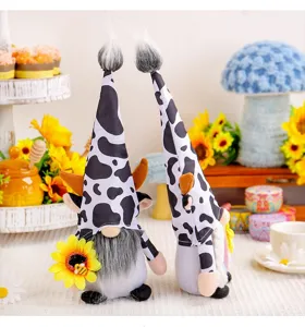 Pair of cow-print gnomes with sunflowers in a rustic festive farmhouse display scene