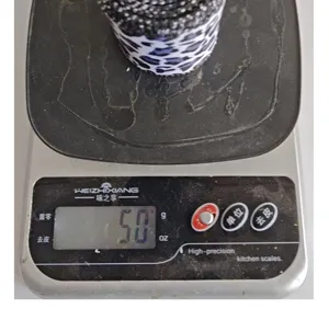 Vue détaillée montrant le poids de 50g d'un rouleau de ruban à motifs noir et blanc