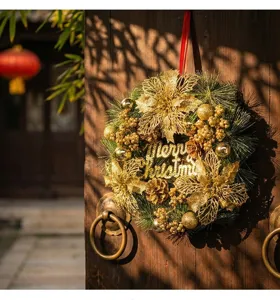 Detail of luxury gold Christmas wreath with Merry Christmas text on a wooden door scene.
