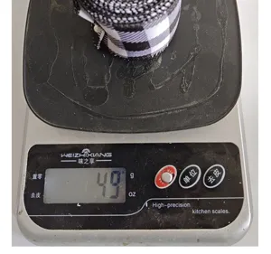 Gros plan d'un ruban à carreaux noir et blanc pesant 49 g sur une balance digitale