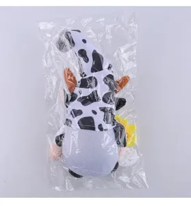 Handmade cow print gnome plush with sunflower detail in clear protective packaging.
