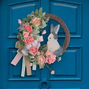 Easter bunny wreath featuring pink roses and decorative ribbons on a vintage blue door