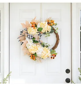 Detailed close-up view of the artificial autumn floral wreath featuring yellow flowers.