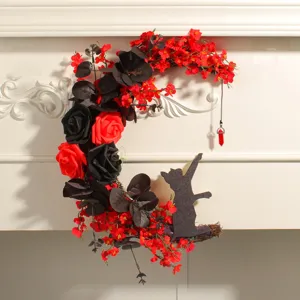 Close-up of crescent moon Halloween wreath with red flowers and cat silhouette