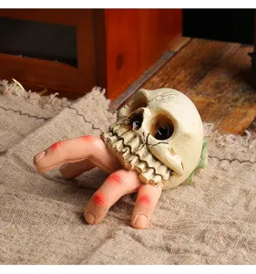Detailansicht eines realistischen Halloween-Schädels aus Harz mit gruseligen Fingern
