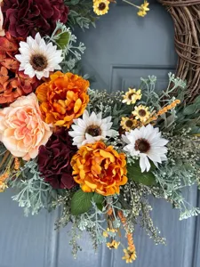 Vista dettagliata di ghirlanda di fiori artificiali con girasoli autunnali per decoro porta
