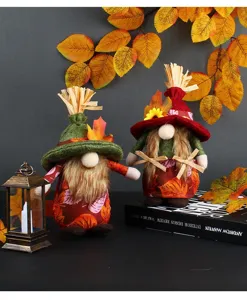 Primer plano de dos gnomos de cosecha con motivos de hojas de otoño y sombreros de paja