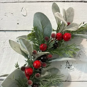 Gros plan d'une branche décorative de Noël avec baies rouges et feuilles givrées