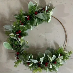 Détail d'une couronne de Noël avec feuilles d'oreilles d'agneau, épines de pin et baies rouges