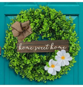 Detailed view of artificial eucalyptus wreath with home sweet home wooden sign
